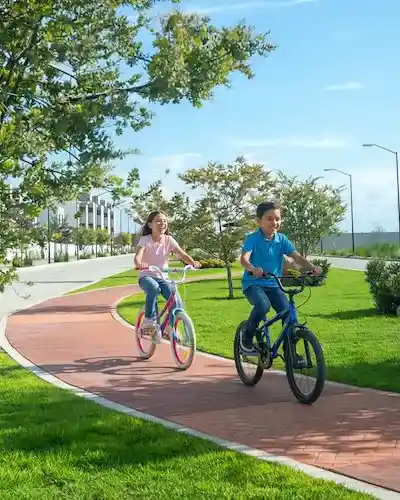 Dos niños en bicicleta por la ciclovía y las áreas verdes