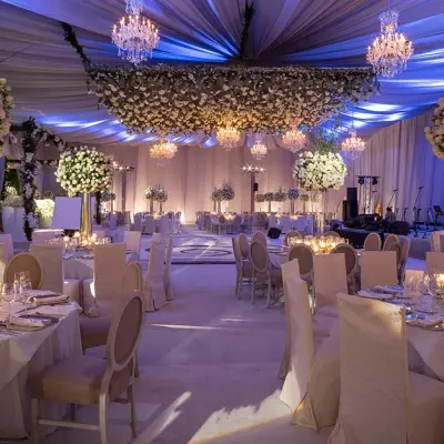 Salón decorado con candelabros, techo de tela y arreglos florales
